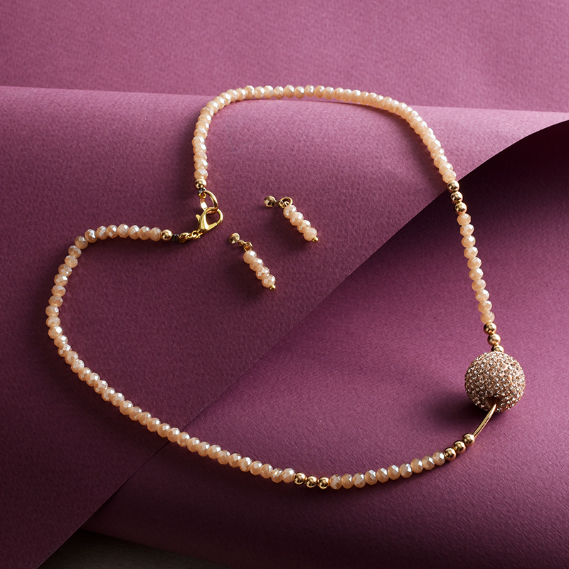 Juego de Collar y Aretes dije Bola de Fuego color Beige.