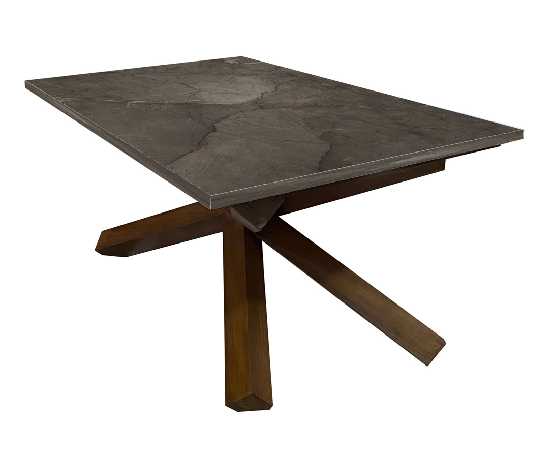 Mesa de centro con base en cruceta y cubierta de mármol gris.