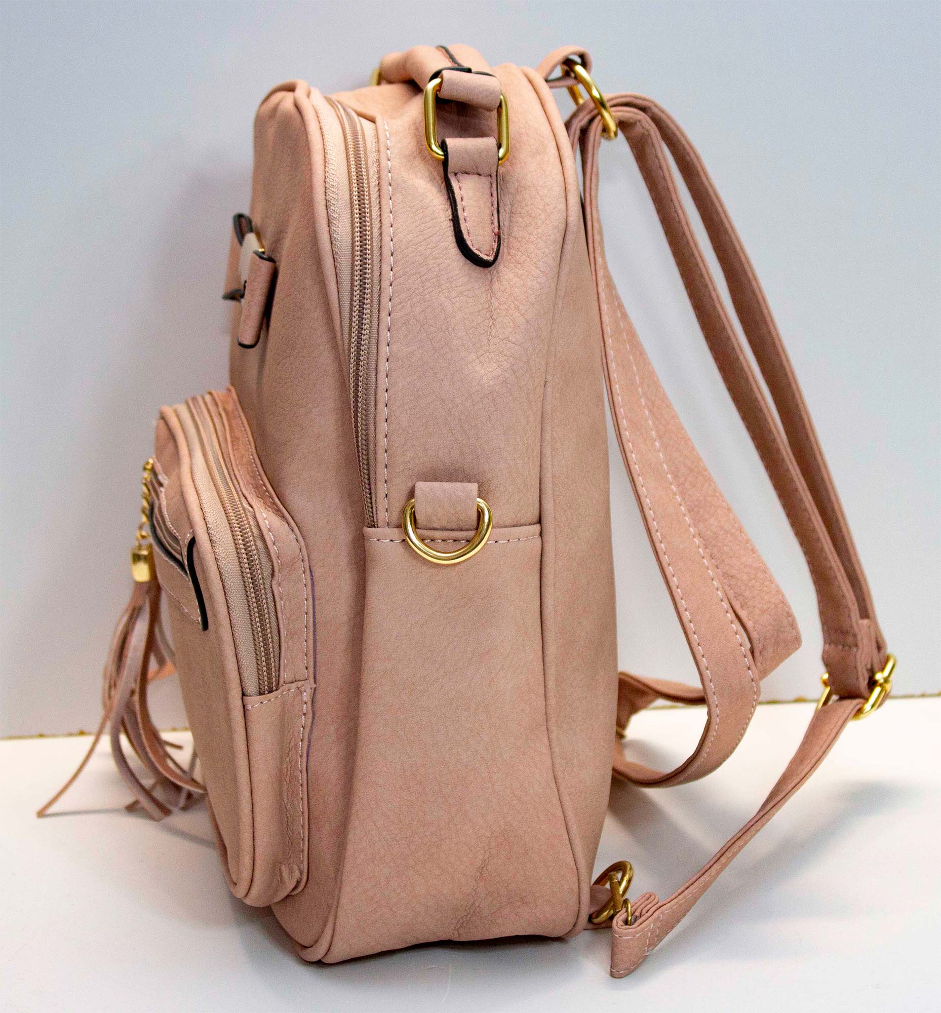 Mochila pequeña de cuero sintetico con forro, varios compartimentos, adorno de moño, correa para diferentes usos.