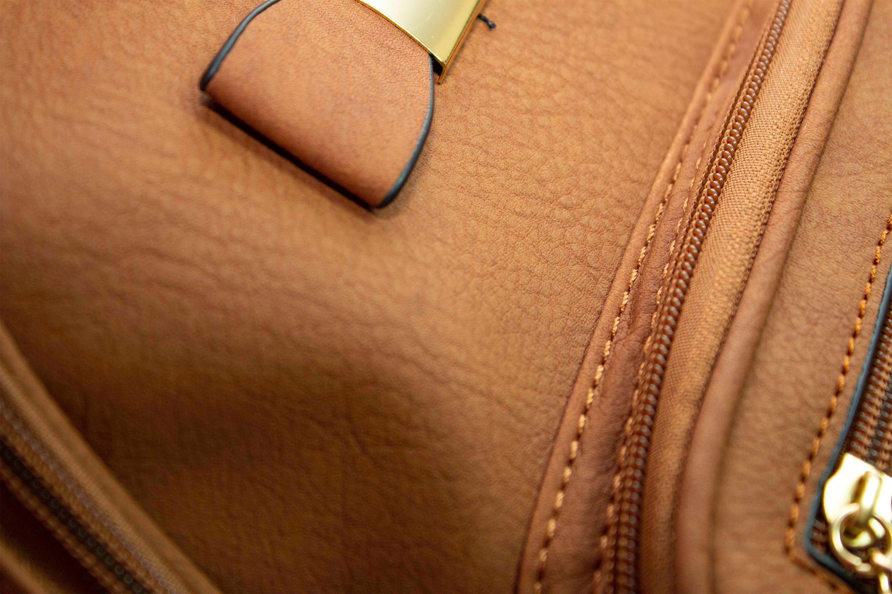 Mochila pequeña de cuero sintetico con forro, varios compartimentos, adorno de moño, correa para diferentes usos.