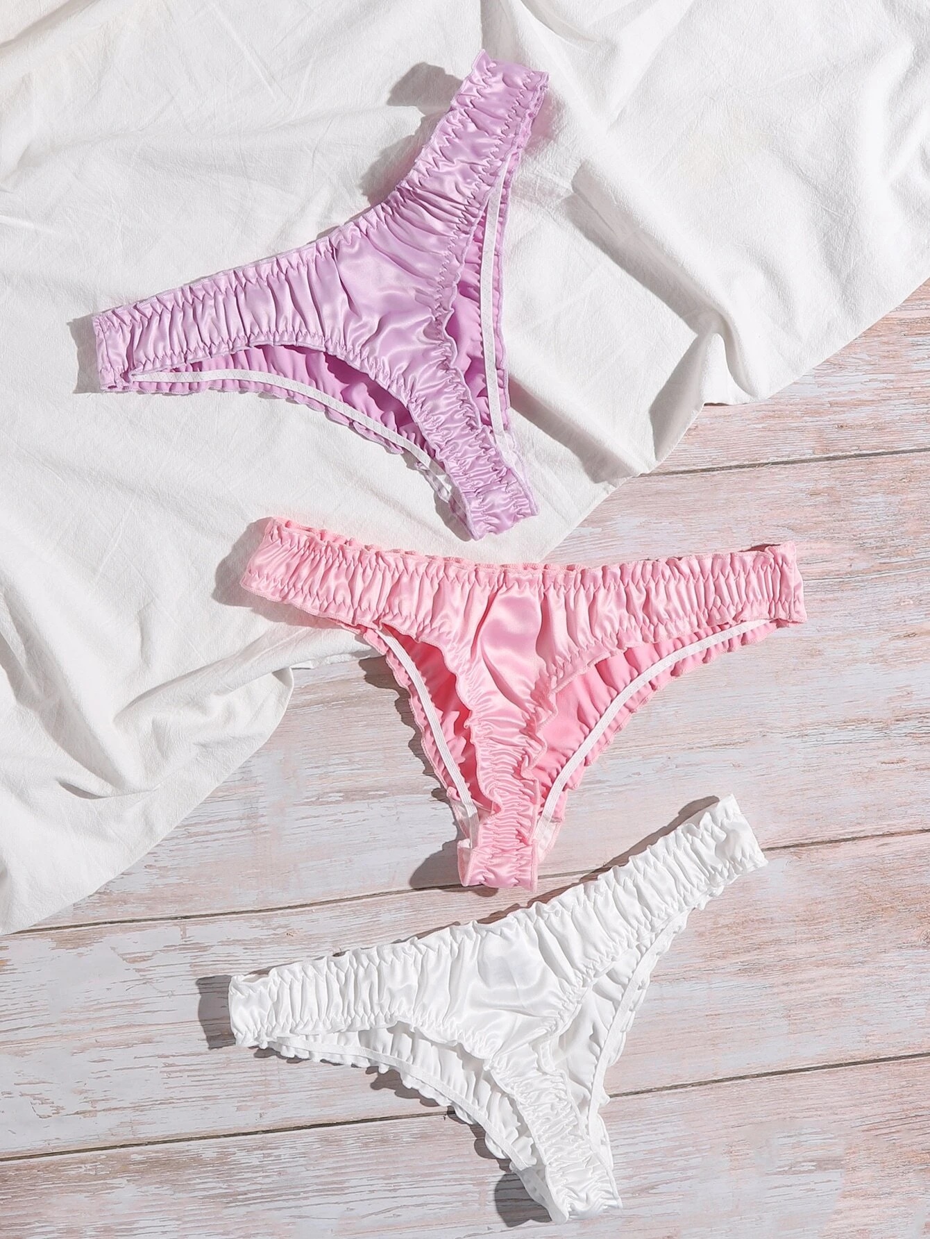 Paquete de tres tangas satinadas con diseño en pliegues. 