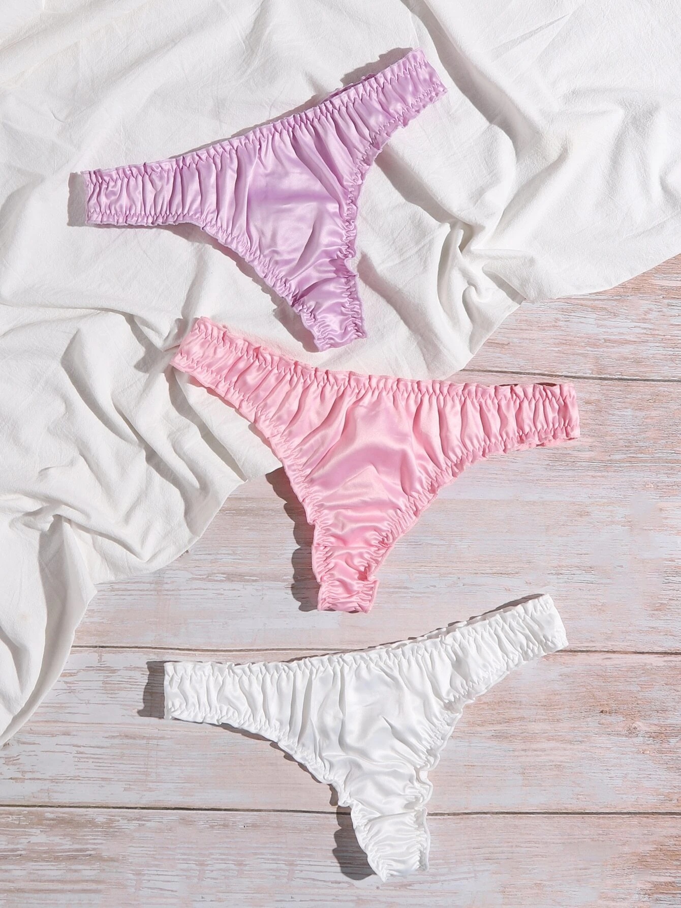 Paquete de tres tangas satinadas con diseño en pliegues. 