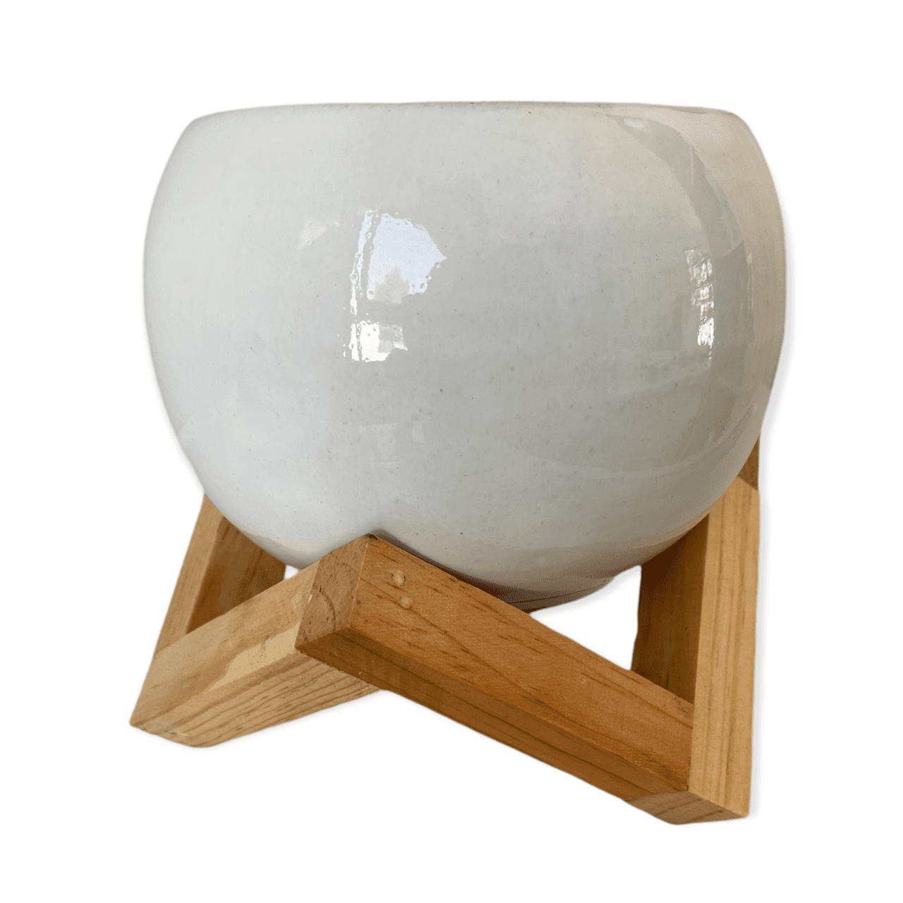 Maceta de cerámica con forma de esfera blanca con base de madera triangular