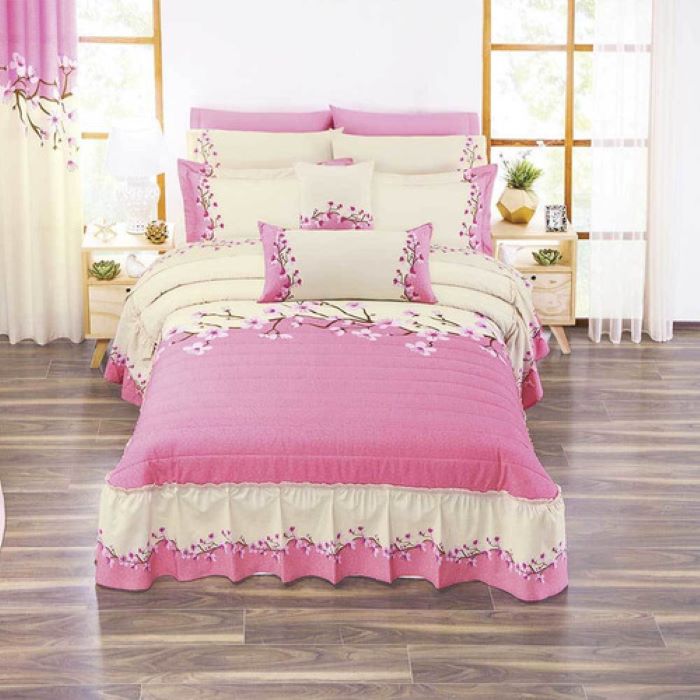 Dormitorio con cama de matrimonio grande con colcha morada cómoda con  cajoneras blancas y acceso a vestidor