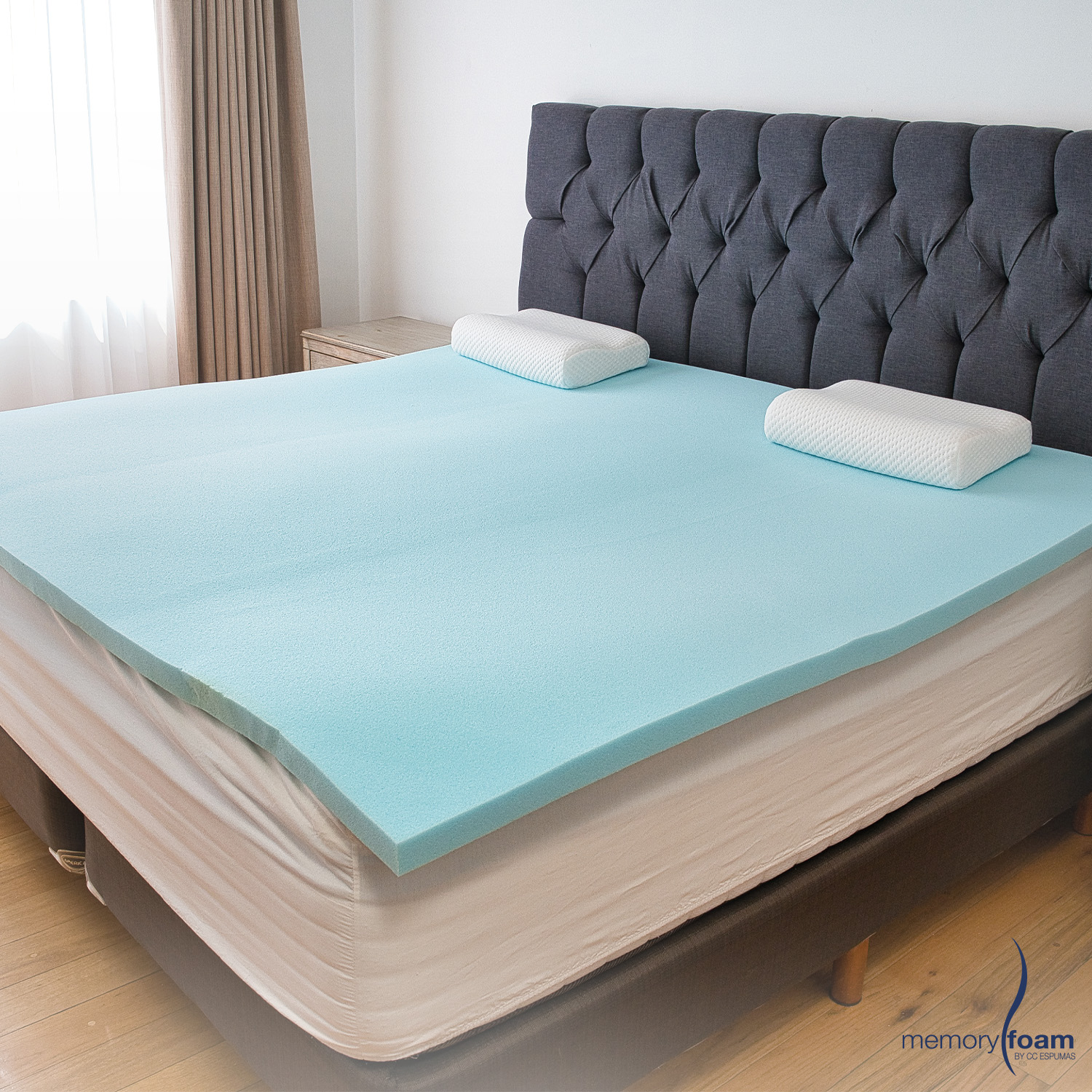Hay una cama con cabecera de madera y una mesa con un libro ai