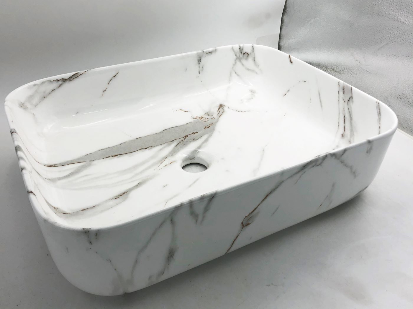Lavabo Cerámico para Baño TIM, forma rectangular acabado blanco marmoleado. De sobreponer, con diseño europeo ideal para todo tipo de baños. Dimensiones 50.0 x 39.0 x 13.0 cms. (base x altura x profundidad)