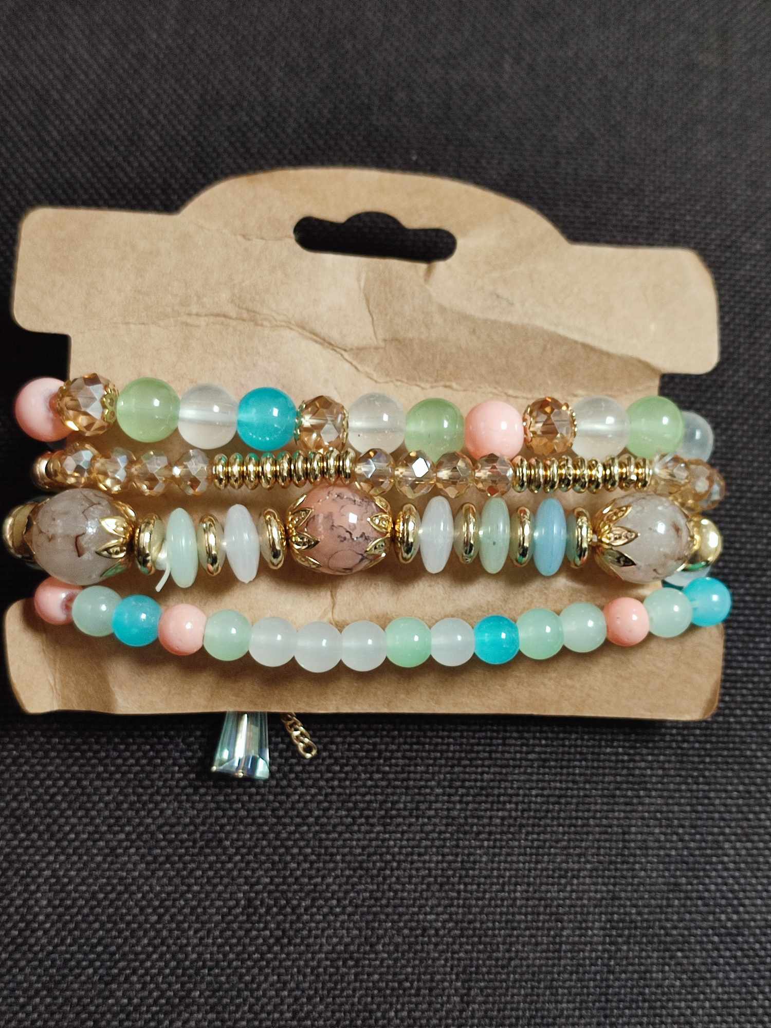 Set de 4 pulseras elasticas en tonos pastel con dije