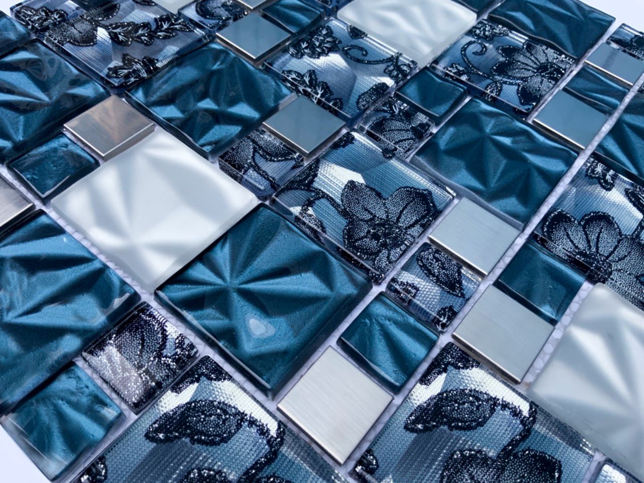 Malla o Mosaico Decorativo de vidrio y acero inoxidable LIR, medida 30 x 30 cms. (base por altura). Diseño en tonos azul, gris y plata con detalles tipo textil y relieve. Caja de 5 piezas.
